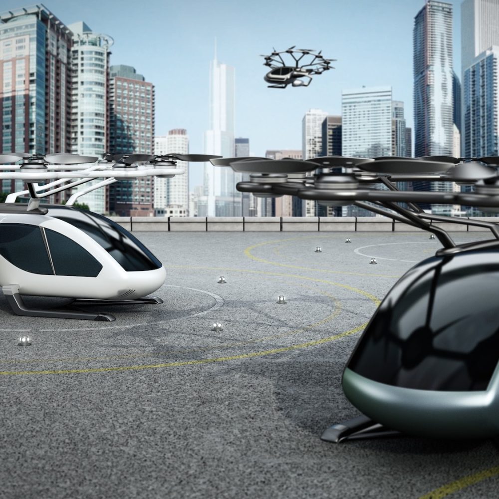 Conceptual eVTOL (electric vertical take-off and landing) aircrafts as a taxi/shuttle service at the helipad on top of a building.